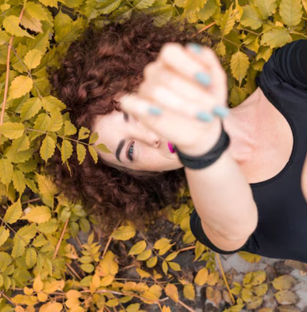 "Curly hair with sun-kissed highlights, enhancing the dimension and movement of the curls."