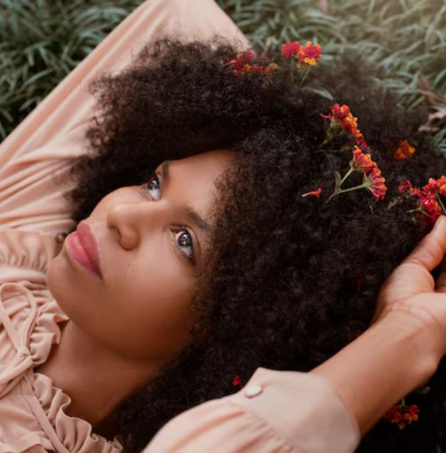 Close-up of loose curly hair strands on the floor, illustrating natural hair shedding."