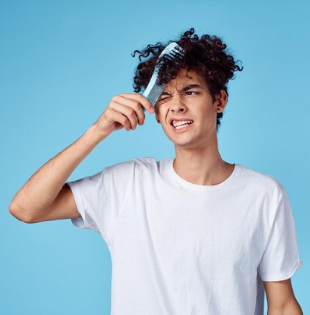 "Young boy with curly hair applying leave-in conditioner to maintain moisture and curl definition."