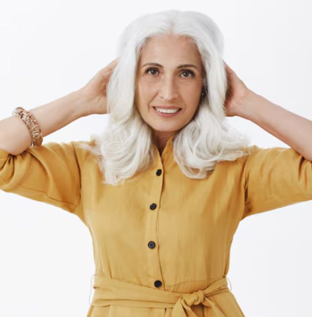  "Neck-length white curly shag bob, featuring layered curls with a tousled, textured look that adds volume and movement to the short hairstyle for naturally curly hair over 50."