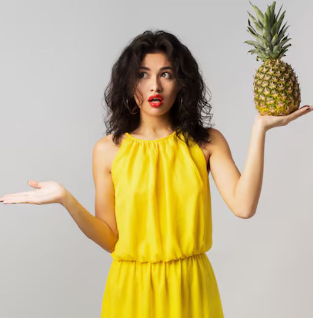 "Close-up of a pineapple hairstyle, showing curly hair secured with a scrunchie or hair tie at the top of the head."